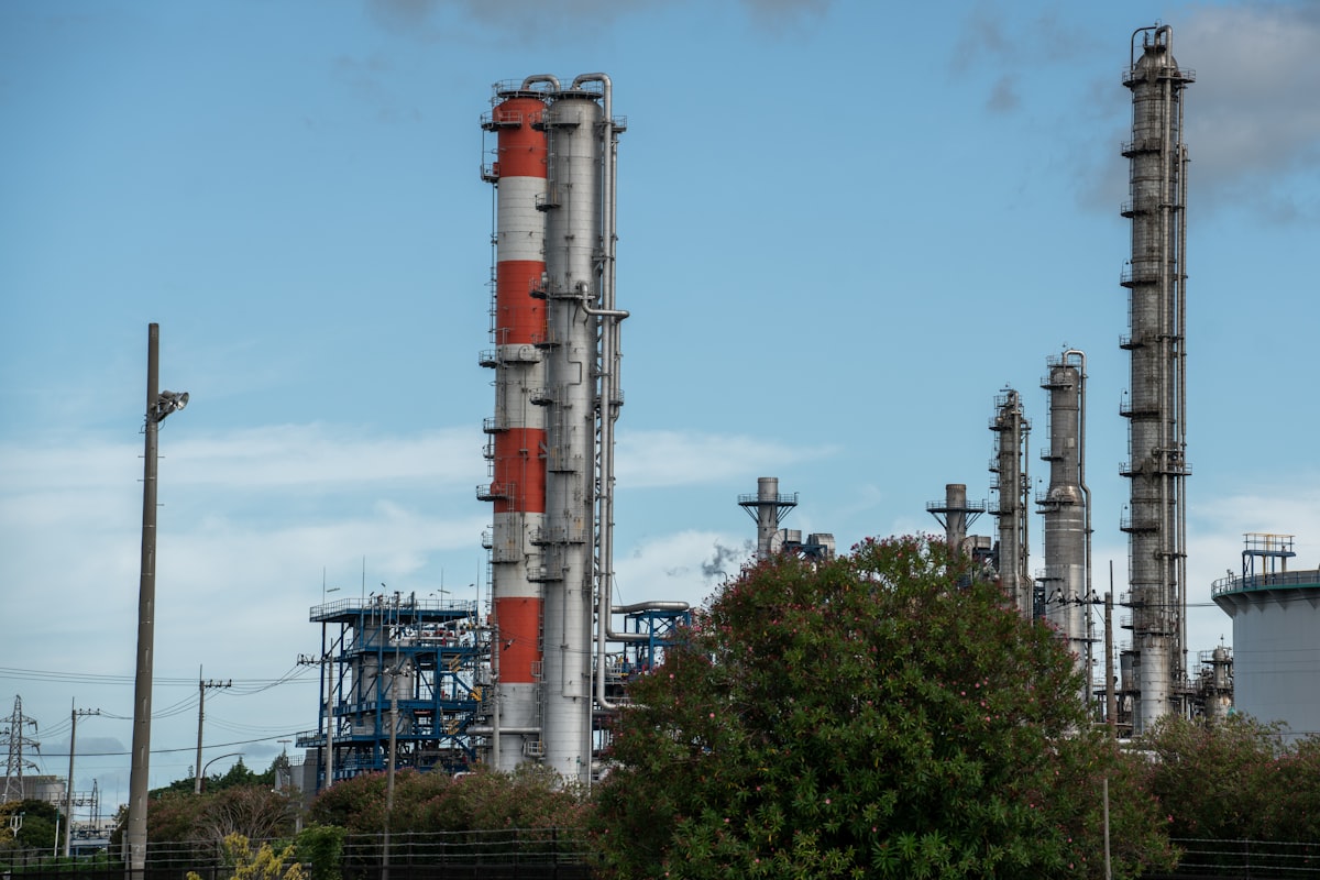 Refinería con torres industriales y cielo despejado